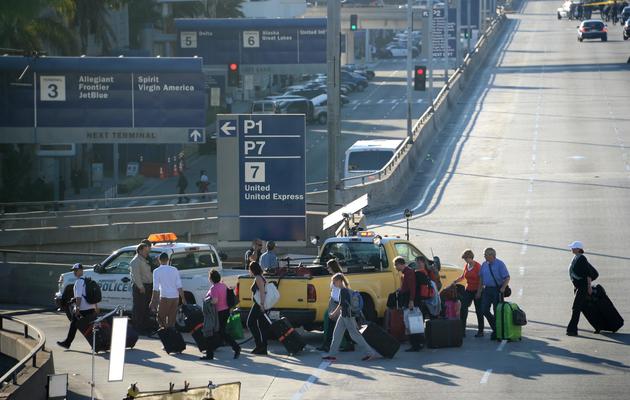 Des passagers quittent l'aéroport international de Los Angeles plusieurs heures après une fusillade, le 1er novembre 2013 [Robyn Beck / AFP]