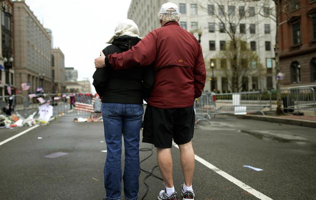 Deux personnes se recueillent le 20 avril 2013 à Boston après les attentats qui avaient endeuillé le célèbre marathon [Timothy  A.Clary / AFP]