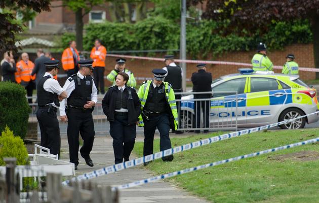 Des policiers près de l'endroit où un homme a été tué et deux suspects blessés dans l'est de Londres, le 22 mai 2013 [Leon Neal / AFP]