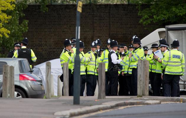 Des policiers près de l'endroit où un homme a été tué et deux suspects blessés dans l'est de Londres, le 22 mai 2013 [Leon Neal / AFP]