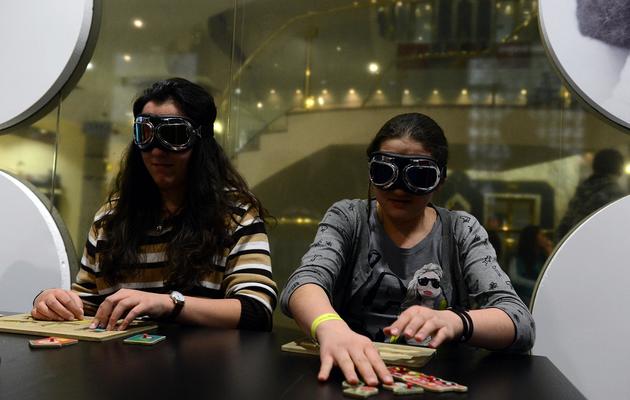 Des visiteurs de "l'exposition invisible" expérimentent un jeu simulant le quotidien des mal-voyants, le 18 décembre 2012 à Varsovie [Janek Skarzynski / AFP]