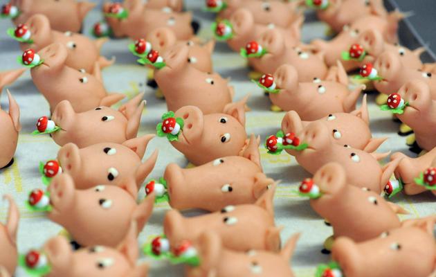 Des petits cochons en massepain, confectionnés à Villingen-Schwenningen, dans le sud-ouest du Land du Bade-Wurtemberg, servent de décoration pour les menus de fin d'année [Patrick Seeger / AFP]