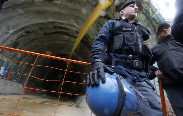 Des policiers gardent l'entrée du tunnel où se sont rassemblés des opposants au projet de TGV Lyon-Turin, le 23 mars 2013 à Chiomonte près du Val de Suse [Marco Bertorello / AFP]