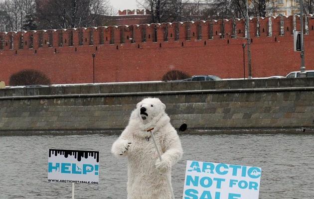 Un militant de Greenpeace vêtu d'un costume d'ours polaire manifeste devant le Kremlin le 1er avril 2013, à bord d'un radeau sur la Moskova [Andrey Smirnov / AFP]