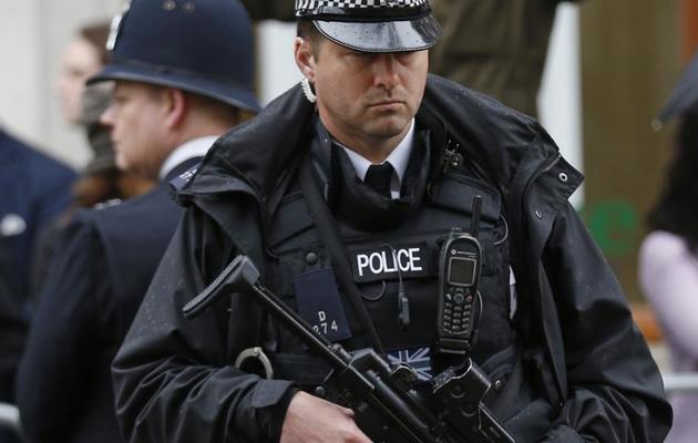 Un policier devant un partisan de Margaret Thatcher le 17 avril 2013 à Londres [Matt Dunham / AFP]