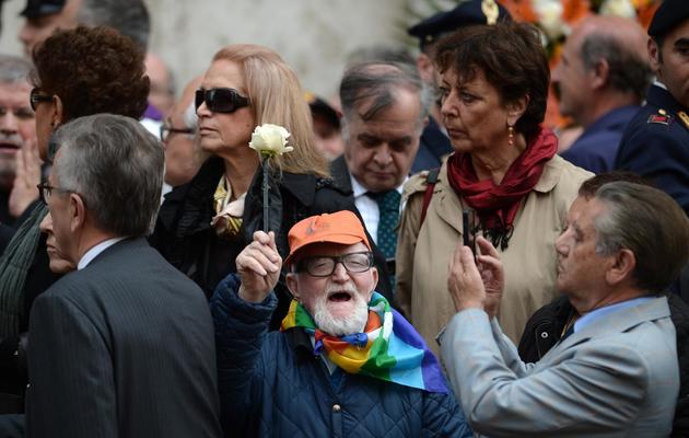Un homme brandit une rose blanche, le 7 mai 2013 lors des funérailles de Giulio Andreotti, à Rome [Filippo Monteforte / AFP]