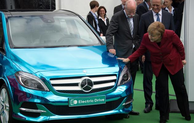 Angela Merkel contemple une Mercedes E-drive, le 27 mai 2013 à Berlin [Johannes Eisele / AFP]