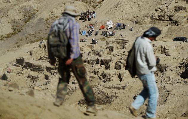 Des travailleurs afghans redescendent du site bouddhiste menacé par une mine, à Mes Ainak, en Afghanistan, le 2 octobre 2012 [Roberto Schmidt / AFP]