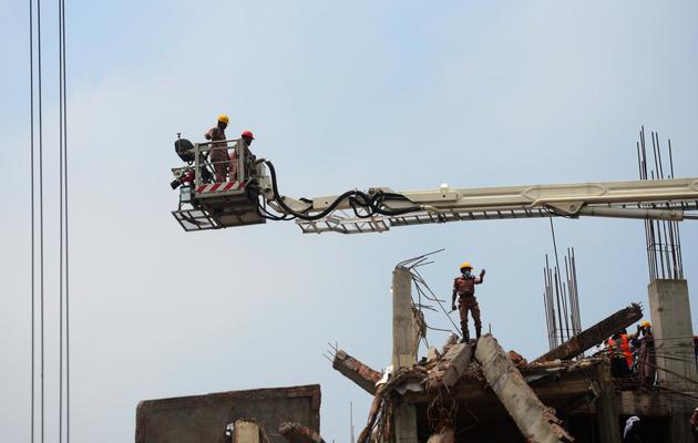 Des pompiers inspectent les ruines de l'immeuble effondré à Savar, près de Dacca, le 28 avril 2013 [Munir Uz Zaman / AFP]