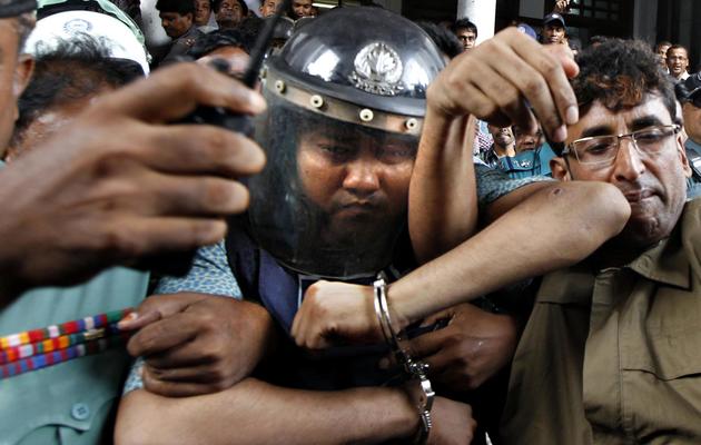 Le propriétaire de l'immeuble effondré au Bangladesh casqué et escorté par la police lors de son audition devant un tribunal à Dacca, le 30 avril 2013 [ / AFP/Archives]