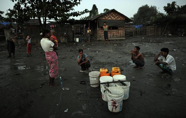 Des habitants du bidonville de Aung Mingalar dans la banlieue de Rangoun attendent le 15 octobre  2012 près d'un puits d'eau [Christophe Archambault / AFP]