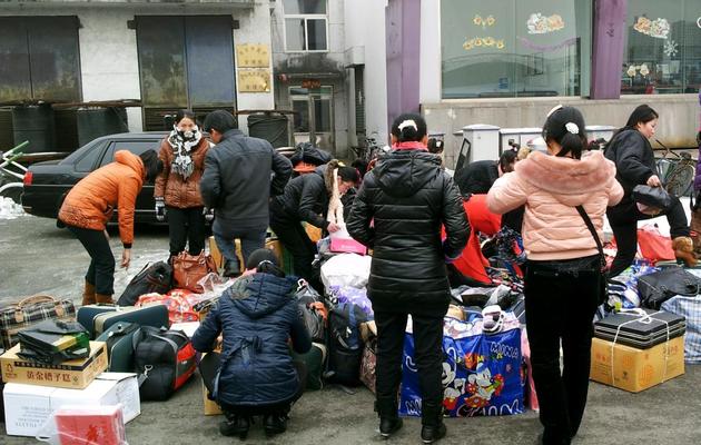 Des femmes nord-coréennes ramassent leurs achats avant de rentrer en Corée du Nord, le 13 décembre 2012 à Dandong [Kelly Olsen / AFP]