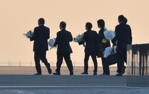 Des fleurs sont apportées sur le tarmac de l'aéroport à l'arrivée le 25 janvier 2013 des corps des victimes japonaises d'In Amenas [Kazuhiro Nogi / AFP]