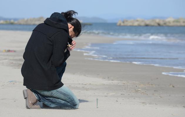 Une Japonaise prie pour son ami victime du tsunami, le 11 mars 2013 à Sendai, dans la préfecture de Fukushima [Toru Yamanaka / AFP]