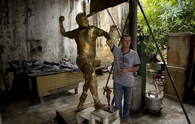 Le sculpteur et caricaturiste Ique et sa statue de Pelé, dans son atelier de Rio de Janeiro, le 22 janvier 2013. [Christophe Simon / AFP]
