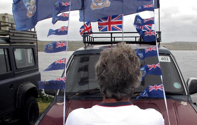 Un homme face aux drapeaux des îles Malouines, à Stanley aux Malouines, le 10 mars 2013 [Tony Chater / AFP]