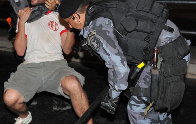 Des policiers maîtrisent un opposant à la privatisation du stade Maracana à Rio de Janeiro en marge de la réouverture du site, le 27 avril 2013 [Tasso Marcelo / AFP]