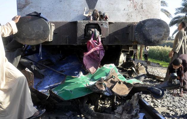 Des Egyptiens inspectent les dégâts provoqués par la collision meurtrière entre un bus et un train dans la province d'Assiout (centre), le 17 novembre 2012 [ / AFP]