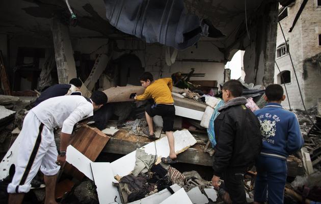 Des Palestiniens fouillent les décombres d'une maison détruite par une frappe aérienne israélienne, le 17 novembre 2012 à Gaza [Marco Longari / AFP]