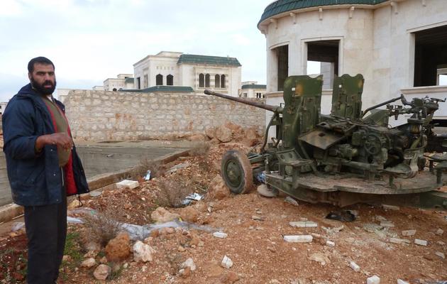 Un rebelle syrien se tient près d'une pièce d'artillerie à l'entrée de la base cheikh Souleimane, près d'Alep, le 9 décembre 2012 [Herve Bar / AFP]