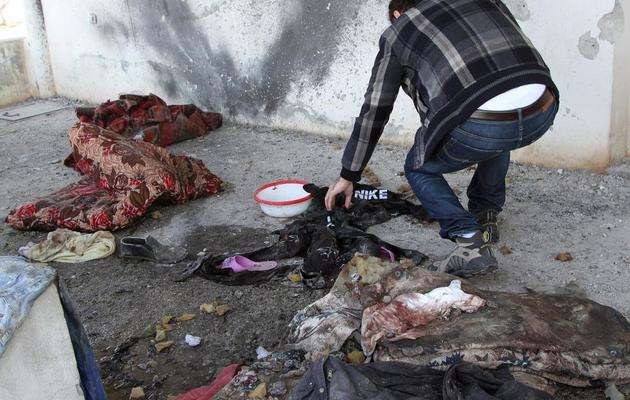 Des habits maculés de sang et  façades de maisons noircies le 23 janvier 2013 à Soueida [Anwar Amro / AFP]