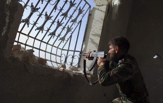 Un combattant rebelle syrien tire le 13 mars 2013 sur des positions de l'armée régulière dans la ville d'Alep, au nord du pays [Jm Lopez / AFP]