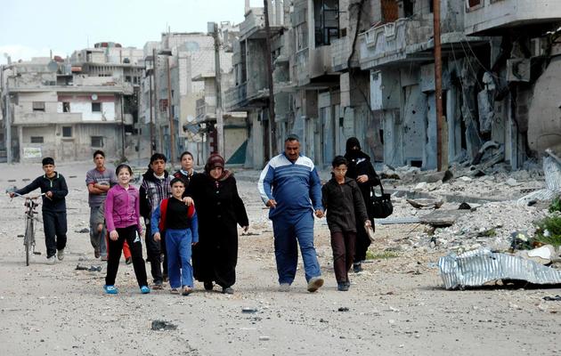 Photo transmise par l'agence syrienne Sana, montrant un groupe de personnes marchant dans une rue de Homs, le 27 mars 2013 [ / SANA/AFP]