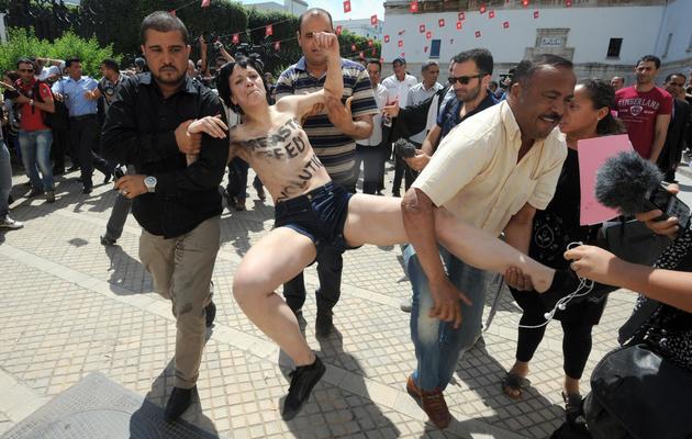 Les forces de sécurité interpellent l'une des militantes Femen, le 29 mai 2013 à Tunis [Fethi Belaid / AFP]