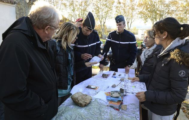Des gendarmes et des volontaires examinent des cartes le 12 novembre 2012 à Barjac lors de recherches pour retrouver une adolescente disparue [Boris Horvat / AFP]