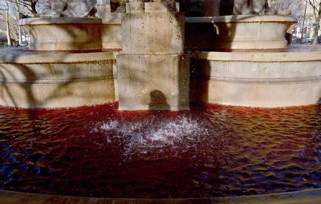 De l'eau rouge ressemblant à du sang coule de la fontaine Palm, place du Châtelet à Paris, pendant une manifestation de médecins libéraux, le 2 décembre 2012 [Miguel Medina / AFP]