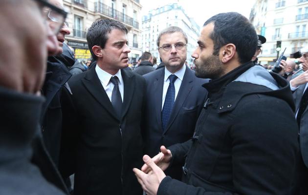 Le ministre de l'Interieur Manuel Valls (G) devant les locaux où ont été tuées trois militantes kurdes, le 10 janvier 2013 [Thomas Samson / AFP]