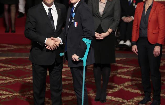 Le Premier ministre François Hollande décore l'escrimeur Ludovic Lemoine, médaillé d'argent aux JO paralympiques de Londres, le 22 février 2013 à l'Elysée. [Jacques Demarthon / AFP]