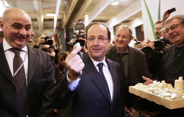 Le président François Hollande tient un bout de fromage le 23 février 2013 au salon de l'agriculture à Paris [Kenzo Tribouillard / AFP]