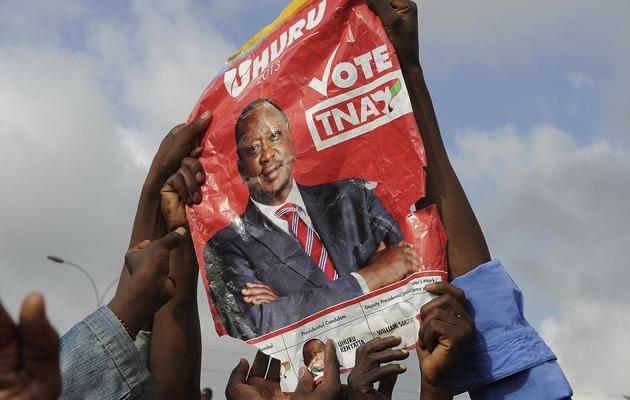 Des sympathisants d'Uhuru Kenyatta brandissent son affiche électorale à Nairobi le 9 mars 2013 [Simon Maina / AFP]