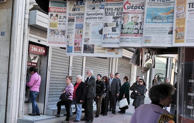 Des Chypriotes font la queue devant un distributeur de billets à Chypre, le 22 mars 2013 [Louisa Gouliamaki / AFP]