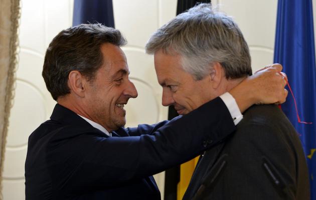 Nicolas Sarkozy remet la Légion d'honneur au ministre belge des Affaires étrangères, Didier Reynders le 27 mars 2013 à Bruxelles [Eric Lalmand / Belga/AFP]