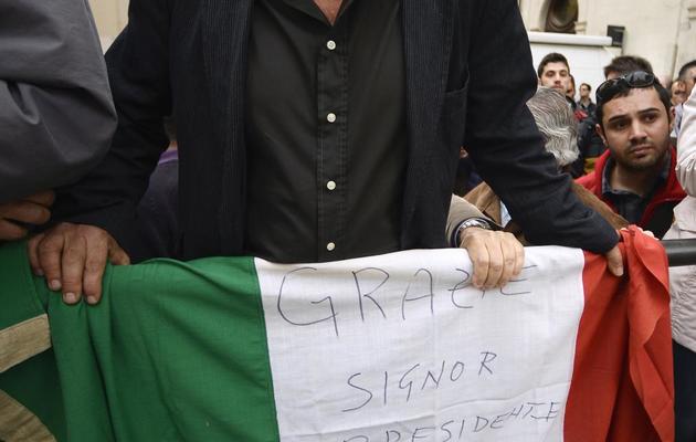 Un partisan de Giorgio Napolitano tient un drapeau où il remercie le président italien sortant, le 20 avril 2013 [Filippo Monteforte / AFP]