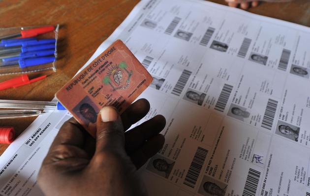 Un homme vérifie l'identité d'un citoyen, à Abobo, dans la banlieue d'Abidjan, à l'occasion d'élections locales, le 21 avril 2013 [Issouf Sanogo / AFP/Archives]