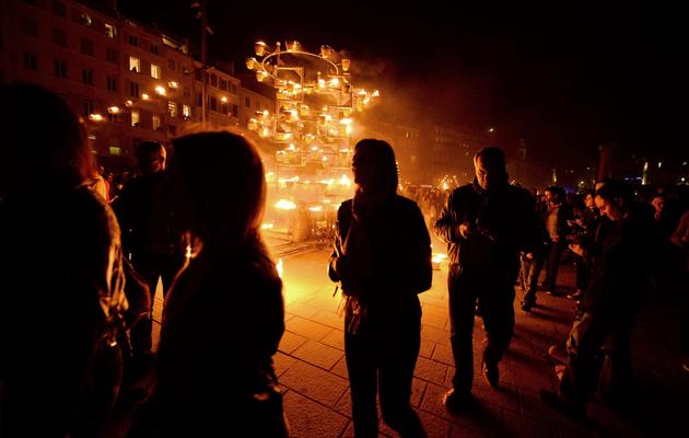 Des personnes marchent sur un pont flottant encadré de flammes, sur le Vieux-Port de Marseille, le 3 mai 2013 [Gerard Julien / AFP]