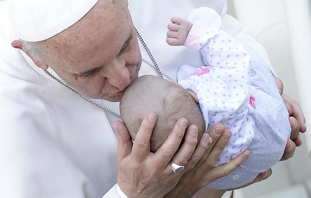 Le pape embrasse un bébé le  12 mai 2013 place Saint-Pierre à Rome à l'issue de la cérémonie de canonisations [Filippo Monteforte / AFP]