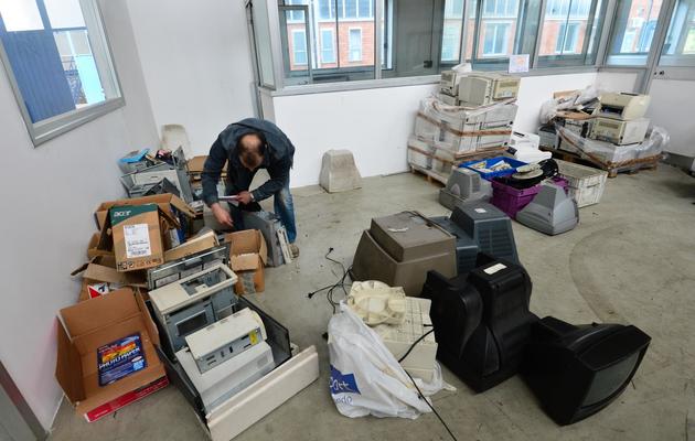 Un ancien employé de la société Maflow, située près de Milan, inspecte le 16 mai 2013, des anciens composants électroniques pour les recycler [Giuseppe Cacace / AFP]
