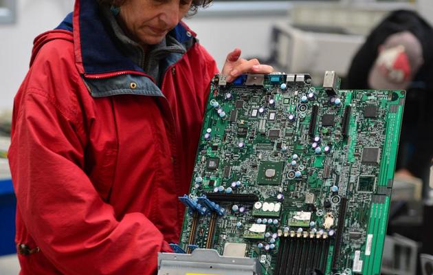 Une ancienne employée de la société Maflow récupère du matériel électronique, le 16 mai 2013, dans l'usine occupée près de Milan [Giuseppe Cacace / AFP]