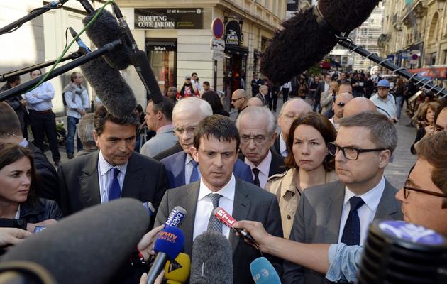 Le ministre de l'Intérieur Manuel Valls (c), le 6 juin 2013 à Paris, sur les lieux de la bagarre mortelle [Bertrand Guay / AFP]