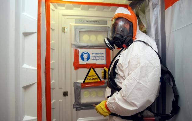 Un employé d'une entreprise de désamiantage, revêtu d'une combinaison spéciale, entre dans une zone contaminée par l'amiante, le 23 avril 2010 [Kenzo Tribouillard / AFP/Archives]