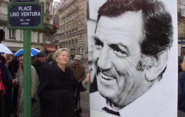 La veuve de l'acteur Lino Ventura, Odette, pose à côté d'une photo de son mari, le 17 décembre 1999 à Paris [Jack Guez / AFP/Archives]