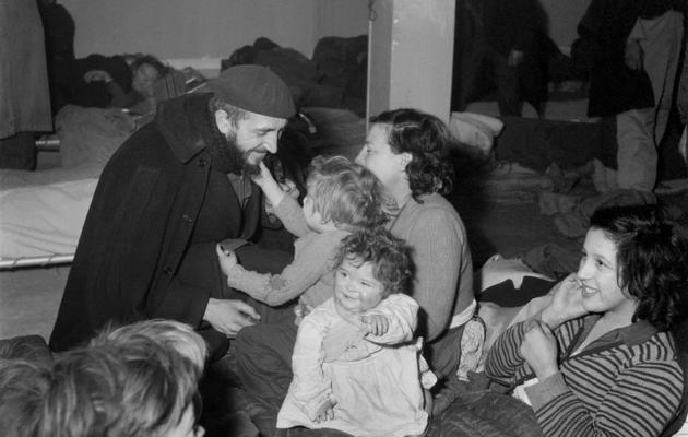 L'Abbé Pierre avec une famile de sans-abris le 2 février 1954 à Paris [ / Intercontinentale/AFP/Archives]