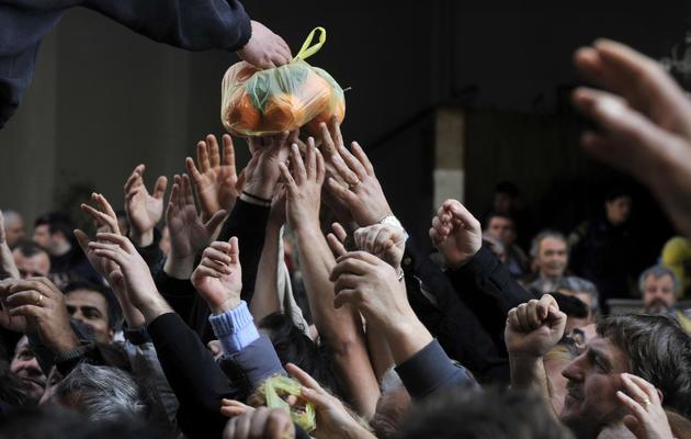 Des Grecs reçoivent des fruits et légumes lors d'une manifestation d'agriculteurs, à Athènes le 6 février 2013 [Louisa Gouliamaki / AFP/Archives]
